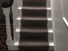 an image of a staircase going up to the top floor with carpet on both sides