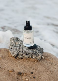 a bottle of perfume sitting on top of a rock