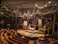 an auditorium filled with people sitting at tables