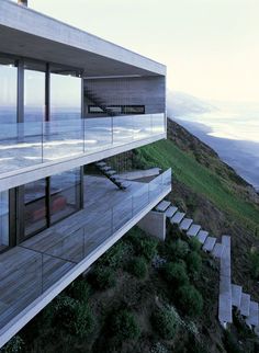 the house is overlooking the ocean and has stairs leading up to it's second floor