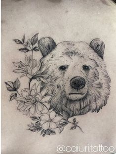 a black and white photo of a bear with flowers on it's back shoulder