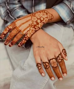 a woman's hand with henna tattoos on it