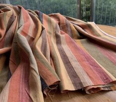 a striped blanket laying on top of a wooden table