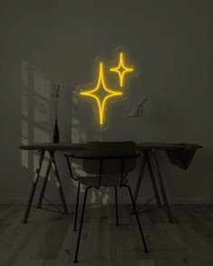 a table and chair with a neon star on the wall