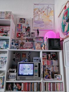 a book shelf filled with lots of comic books and magazines next to a tv set