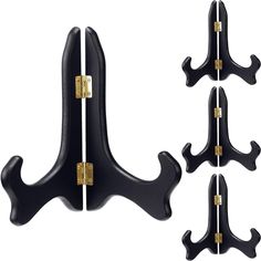 four black coat hooks with gold hardware on each one and the other two are shown