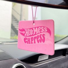 a pink sign that says homeless express hanging from the front of a car's dashboard