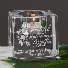 a clear glass candle holder with a floral design on it and the words, beautiful soul is never forgotten