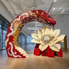 two red and yellow sculptures in an empty room with wood flooring on the ground