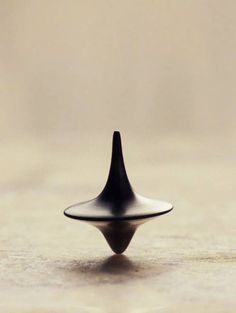 a small black object sitting on top of a table next to a white wall and floor