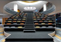 an empty auditorium with black seats and yellow trim on the steps to the second floor