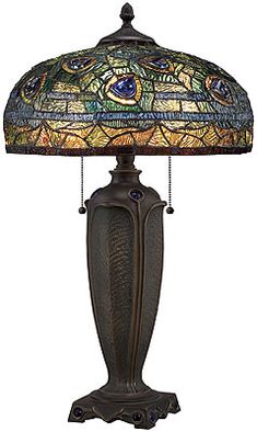 a table lamp with a stained glass shade on it's base and chain link at the bottom