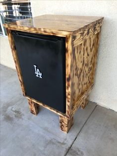 a wooden cabinet sitting on the side of a building