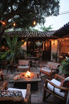 a patio with chairs, tables and a fire pit