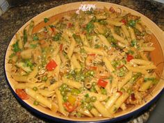 a bowl filled with pasta and vegetables on top of a counter