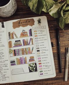 an open book on top of a wooden table next to a cup of coffee and pen