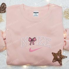 Introducing our Pink Coquette Bow x Nike Embroidered Shirt, a perfect blend of elegance and sporty style. This unique collaboration showcases a feminine pink bow beautifully embroidered on a classic Nike shirt, creating a stunning statement piece. Crafted with premium quality materials, this shirt ensures comfort and durability. Its eye-catching design effortlessly combines fashion and athletic vibes, making it a must-have addition to any girl’s wardrobe. Whether you’re hitting the g Cute Nike Air Shirt, Cute Pink Nike Hoodie, Preppy Nike Hoodies, Disney Hoodies Pink, Cute Sweat Shirt Nike, Nike Rhinestone Hoodie, Nike Sweatshirts Womens Pink, Candy Cane Nike Sweatshirt, Cheap Pink Sweatshirt With Letter Embroidery