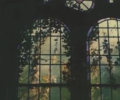 two stained glass windows with trees and sky in the backround, one is dark