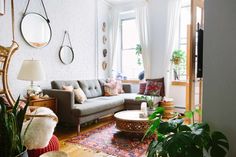 a living room filled with furniture and lots of plants