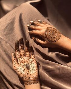 a woman's hands with henna tattoos on them