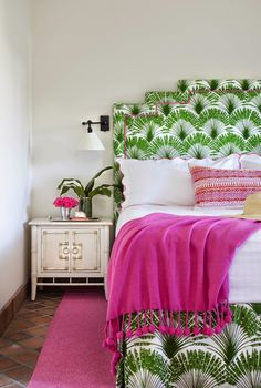 a white bed with pink and green decor