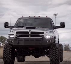 the front end of a silver truck on a road