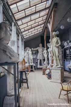 a room filled with lots of white statues and chairs next to each other on hard wood flooring