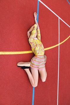 a woman is laying on the ground with her hands behind her head and arms in the air