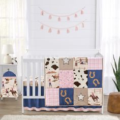 a baby crib bedding set with horse and cow prints on it, along with a potted cactus