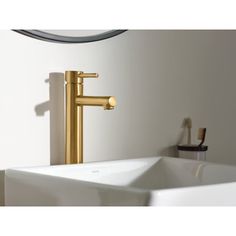 a white sink sitting under a mirror next to a faucet