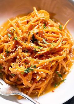 a white bowl filled with pasta and topped with parsley