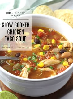 a bowl of slow cooker chicken taco soup with tortilla chips on the side