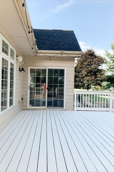 a white deck with sliding glass doors leading to a patio