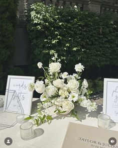 the table is set with white flowers and place cards