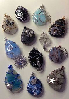 twelve handmade glass ornament ornaments displayed on a white surface with wire wrapped around them