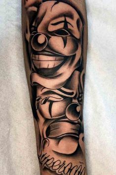 a man's leg with a tattoo on it that has a clown face in the middle