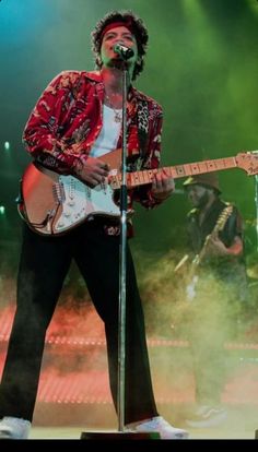 a man that is standing up with a guitar