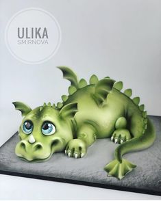 a green dragon cake sitting on top of a table