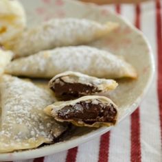 an assortment of pastries on a plate with banana slices and powdered sugar in the middle