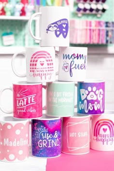 a stack of coffee mugs sitting on top of a pink tablecloth covered floor