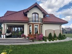 a house with a red tiled roof and stairs leading up to the front door is shown