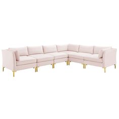 a white sectional couch with gold legs