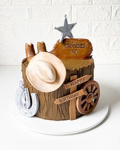 a birthday cake made to look like a tree stump with hats and horseshoes on it