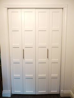 an empty room with white doors and wood flooring on the side of the wall