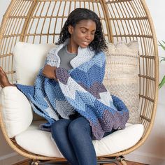 a woman sitting in a chair holding a blanket