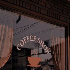 a coffee shop sign is reflected in the window