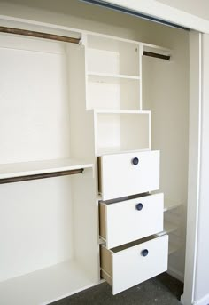 an empty closet with white drawers and shelves