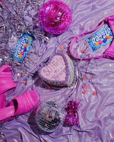 there are many items on the table that is purple and silver, including a heart shaped cake