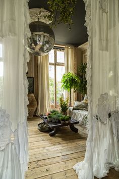 a room with white curtains and wooden floors