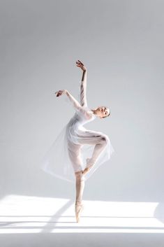 a ballerina in white is posing for the camera